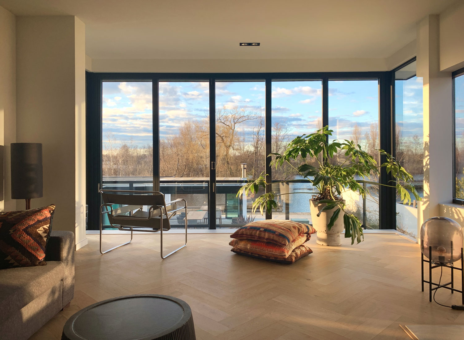 uitzicht, woonkamer, kelim kussens, waterfront, solarlux kozijnen, zwarte kozijnen