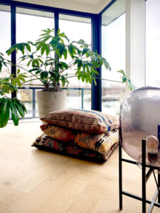 rookglas lamp, kelim kussens, visgraat eiken vloer, grote plant